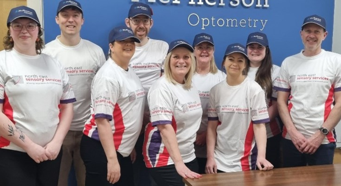 group of people smiling, wearing NESS charity tshirts